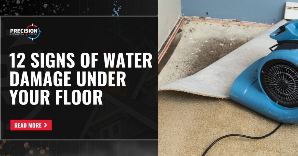 12 Signs of Water Damage Under Your Floor—carpet lifted to reveal mold and moisture damage, with a blue air mover drying the area.