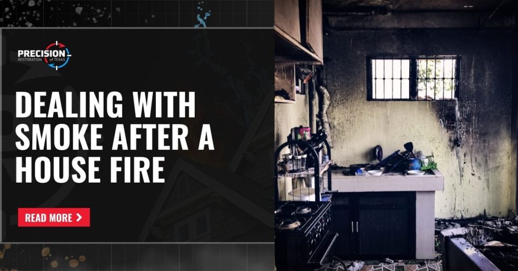 Smoke after a house fire leaves dark stains on a kitchen wall and ceiling. Precision Restoration graphic showing a fire-damaged kitchen covered in black soot and residue from smoke after a house fire, with a call-to-action to learn more