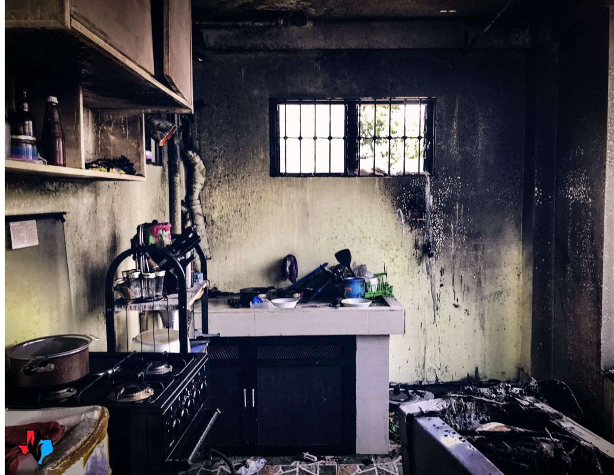 Kitchen covered in soot and black stains from smoke after a house fire
