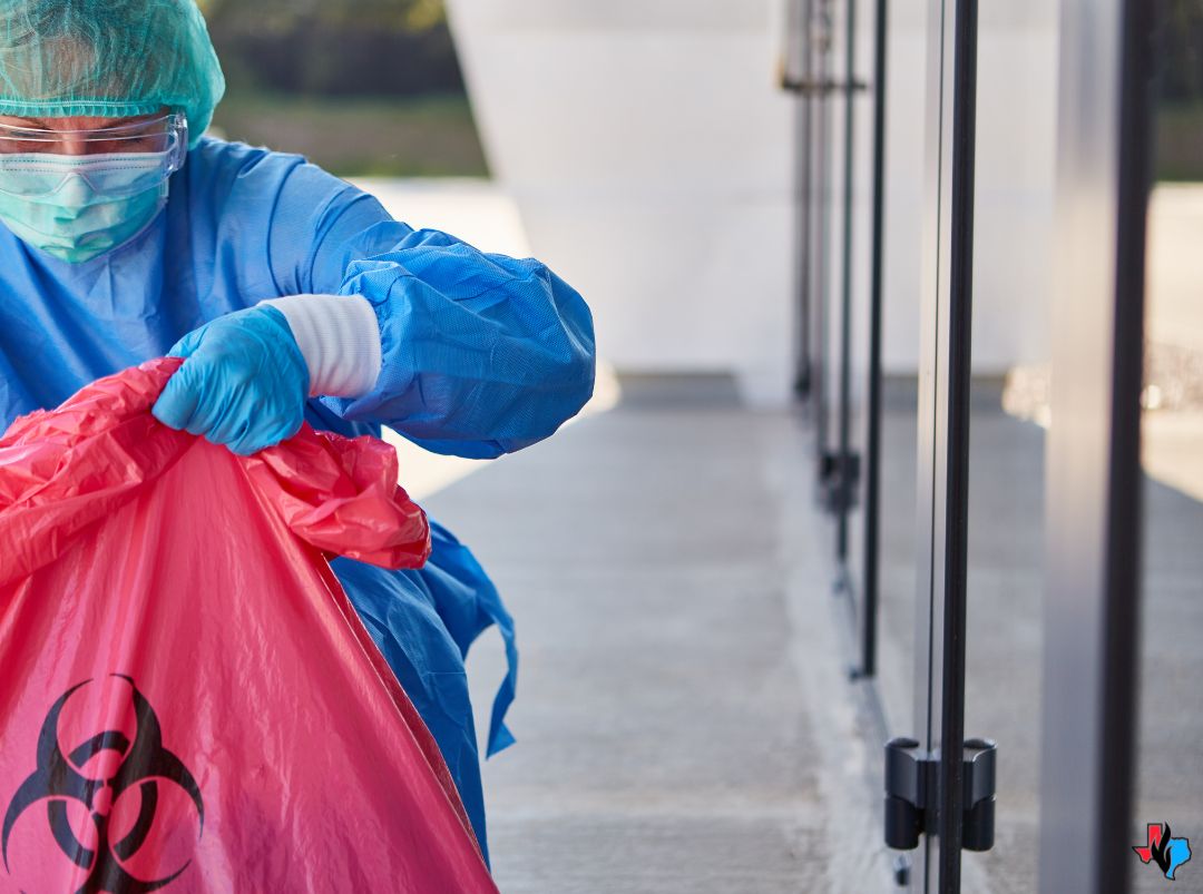 A technician wearing protective gear handles biohazard waste during a cleanup in The Woodlands, TX. The image shows proper biohazard cleanup and restoration procedures in action.