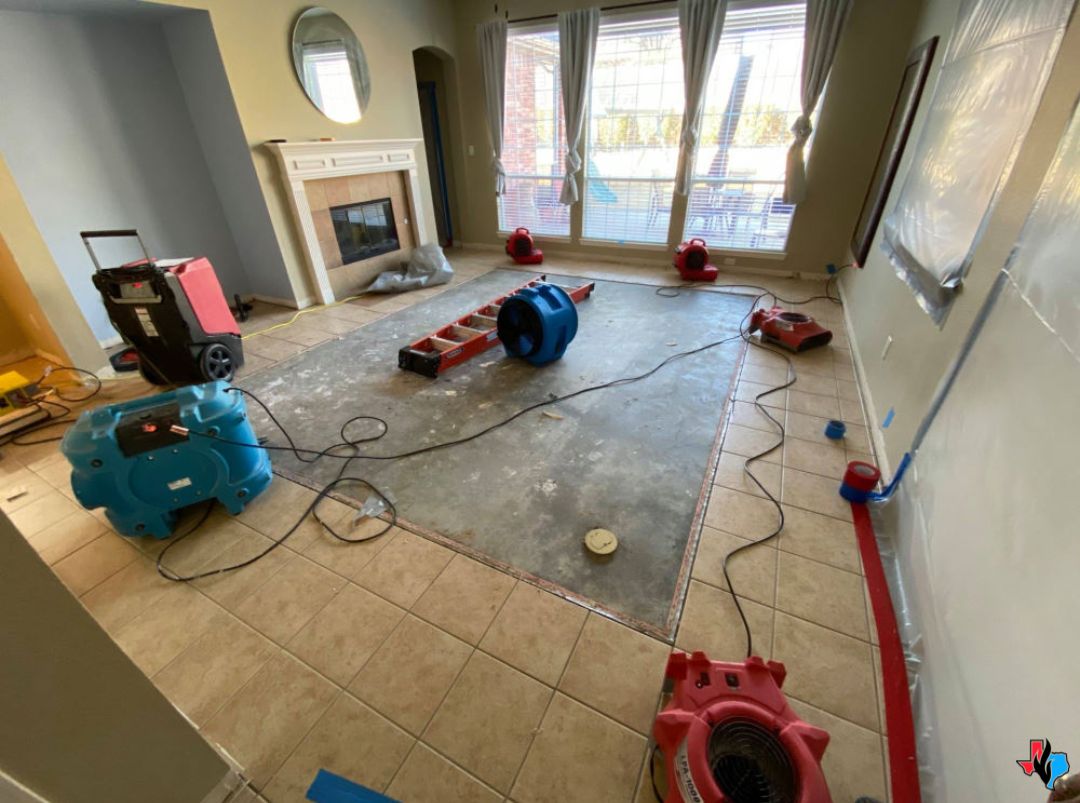 Water Damage Restoration in Humble, Texas – Interior of a home undergoing water damage restoration with industrial air movers and dehumidifiers set up on a partially removed floor. Precision Restoration offers 24/7 emergency water damage repair services in Humble, TX.