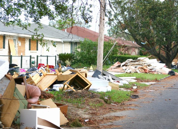 Storm debris and damaged household items are piled along a residential street in Houston, Texas after severe weather. The image highlights the need for clean up and debris removal in Houston, Texas following a major storm.