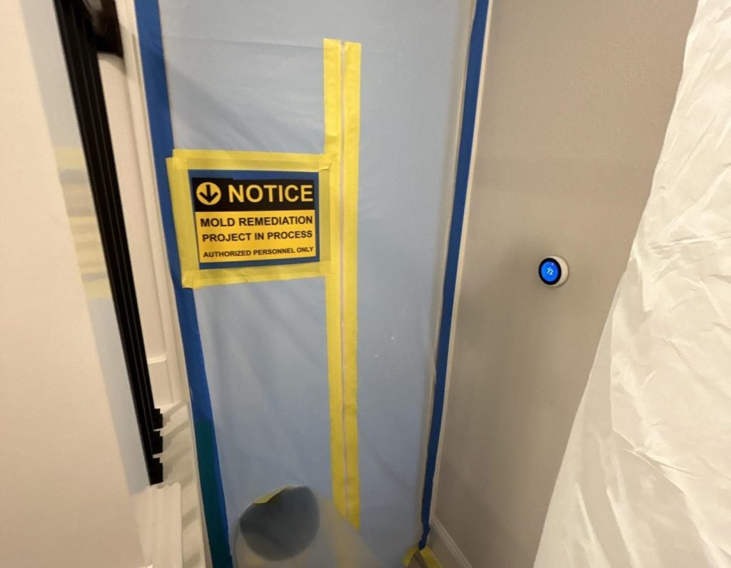 Mold removal in Spring TX showing a sealed containment area with a warning sign indicating an active mold remediation project in progress, designed to restrict access and prevent contamination during the cleanup process.
