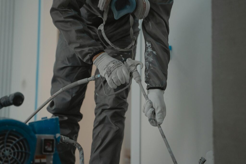 Mold remediation professional in protective gear treating mold in Houston TX home
